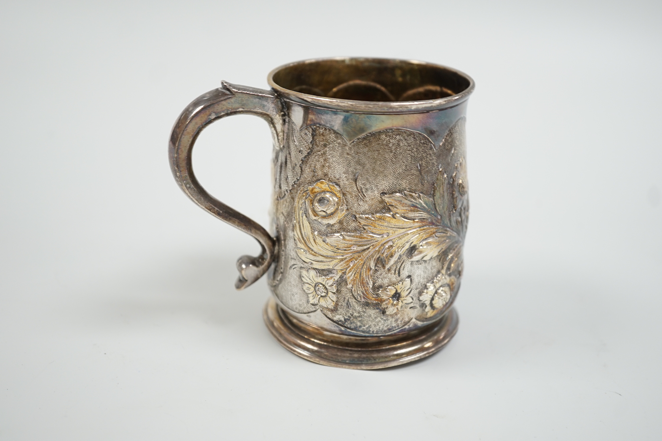 A George II silver mug, with later embossed decoration, makers mark rubbed, London, 1724, 9cm, (a.f.) 6.1oz.